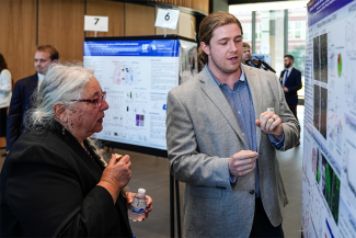 Senior Associate Vice President for Research Linda Dwoskin talks with Tanner Anderson about his poster: “Serotonin, Psychedelics, and Claustrum Signaling to the Anterior Cingulate Cortex.”